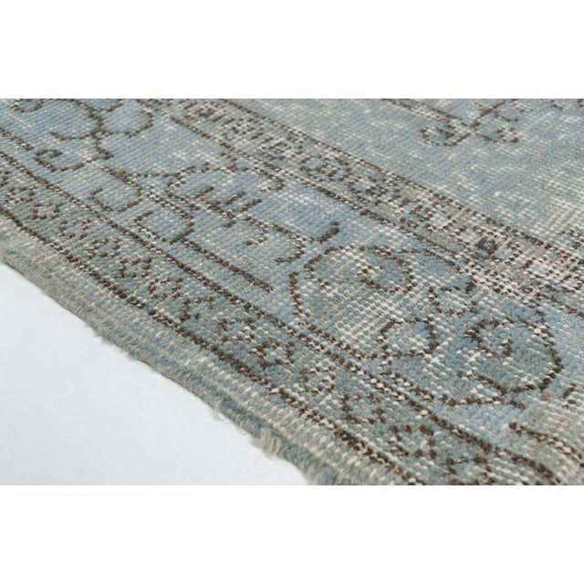 This is a vintage Turkish Oushak rug from the Mid 20th Century. The piece was hand-knotted.