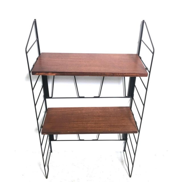 A 1960s Italian-made modular bookcase made of teak veneer, featuring two fully adjustable shelves and metal uprights....