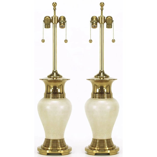 Pair of modern table lamps with heavy brass open footed basses and flanged vase form tops. The vase form body is ivory...