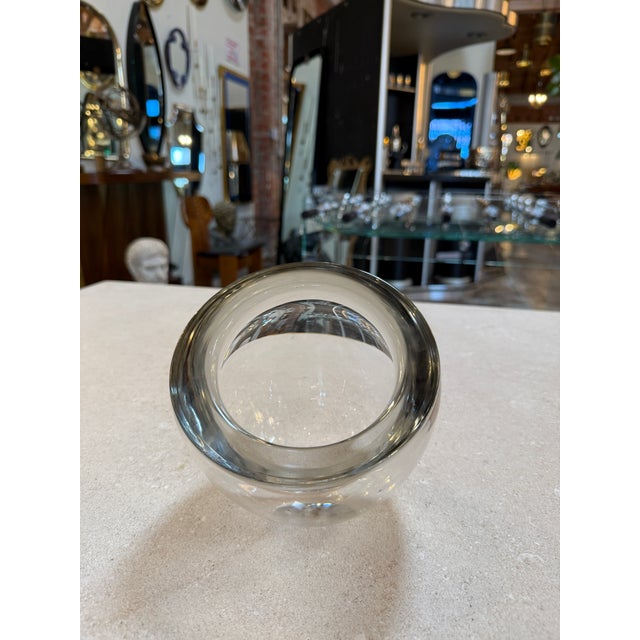 A beautifully minimal Murano glass vase formed as a rounded orb with a dramatically angled opening, showcasing the refined...