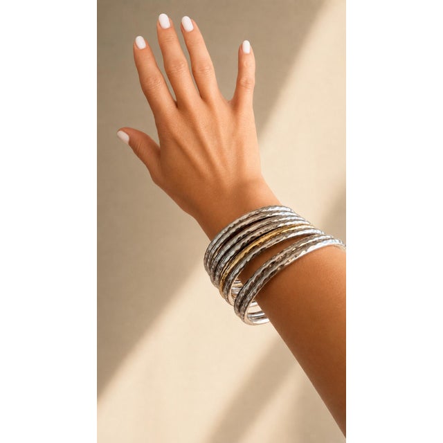 A luxurious set of eight Italian stacking bangles from Roberto Coin’s Martellato Collection. The grouping features seven...