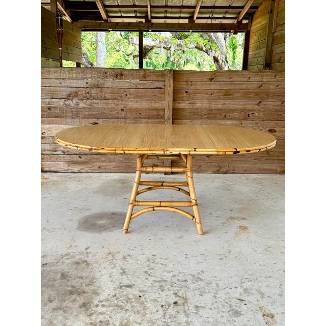A striking vintage coastal dining table crafted from natural burnt bamboo and rattan, showcasing timeless island elegance...