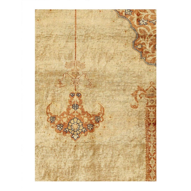 Fine Hand knotted in a lightly distressed, luminous silk body originating from Persia in 1900, this antique Tabriz rug...