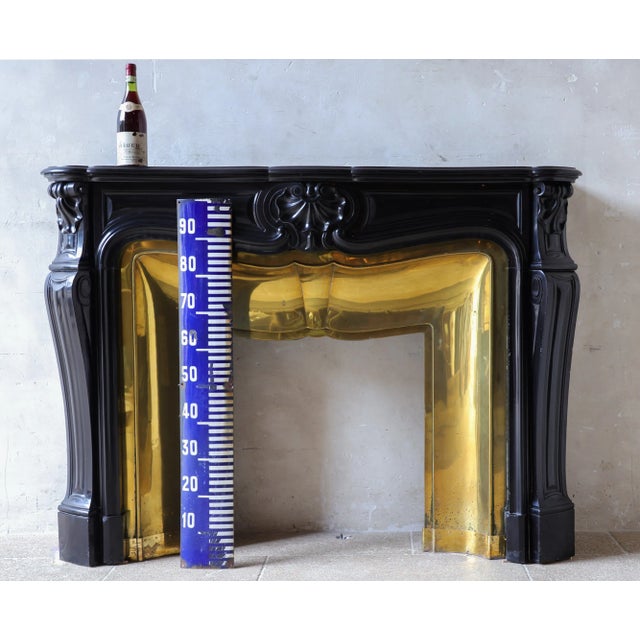Black marble "trois coquilles" fireplace. Antique french fireplace made of black marble, decorated with three shell...
