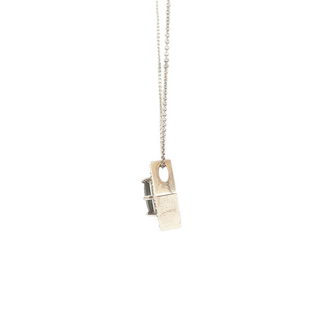 This pendant necklace is crafted with 14k gold. The piece features a central square-cut blue sapphire, accented by round...