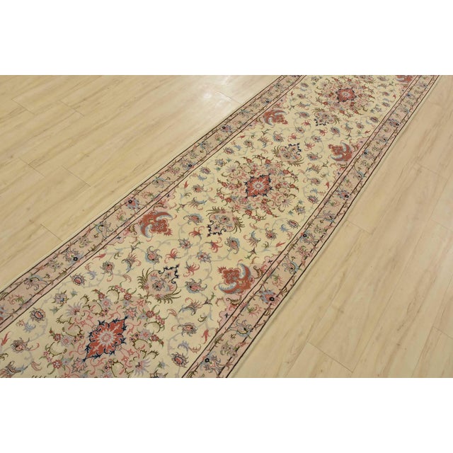 An authentic vintage traditional Tabriz runner, hand-knotted with fine wool and silk highlights using natural dyes. This...