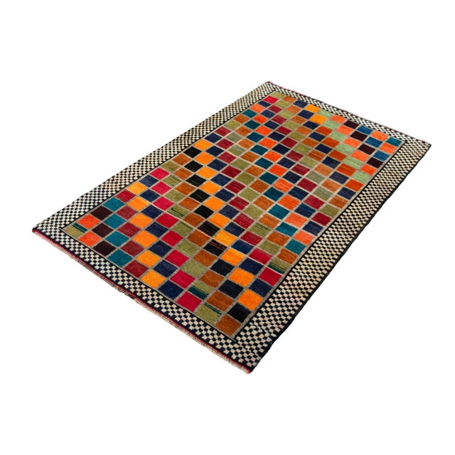 A real eye-catcher! This colorful Gabbeh nomad rug impresses with a vibrant checkered pattern that was traditionally...