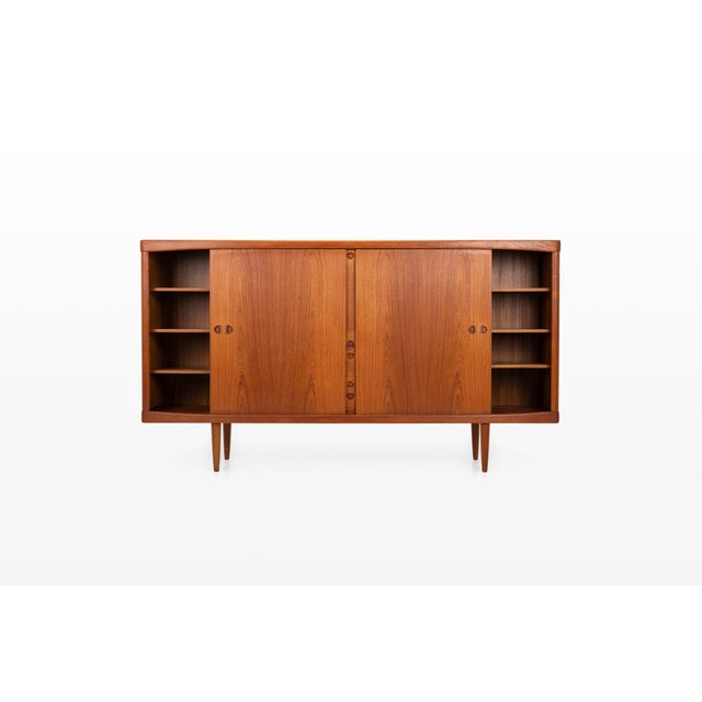 An elegant danish vintage highboard in teak by bramin, featuring gently curved front edges, distinctive recessed handles...