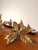 Elegant vintage wall lamp featuring two sculptural leaf-shaped light points connected by a flowing curved arm. Crafted in...