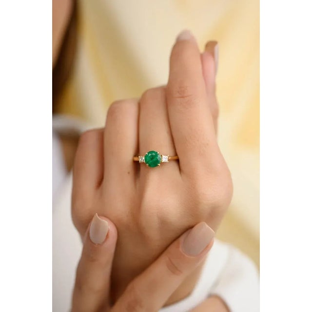 This is part of Chairish’s Fine Jewelry assortment. Emerald and Diamond Three-Stone Engagement Ring in 14K Gold featuring...