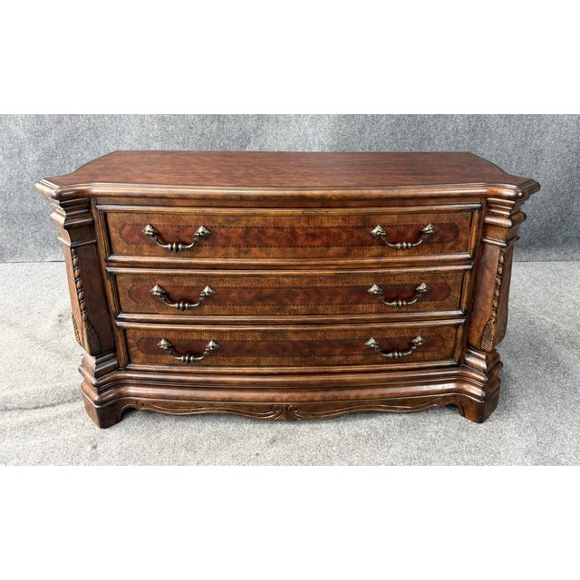 This Michael Amini Windsor Court three drawer low dresser features a richly figured wood finish, elegant serpentine front,...
