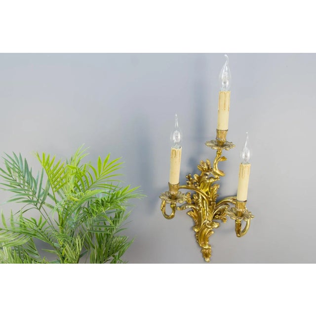 Large Louis XV French Rococo style three – arm sconce. Curvy asymmetrical acanthus leaf-like gilt bronze scrolls in...