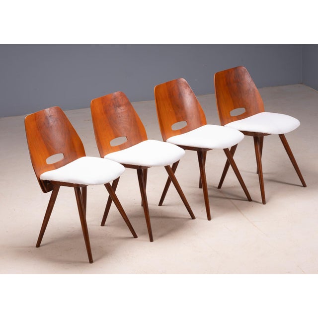 A distinctive set of four vintage “Gentleman” chairs by Tatra Pravenec, featuring shaped wooden backrests with integrated...