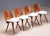 A distinctive set of four vintage “Gentleman” chairs by Tatra Pravenec, featuring shaped wooden backrests with integrated...