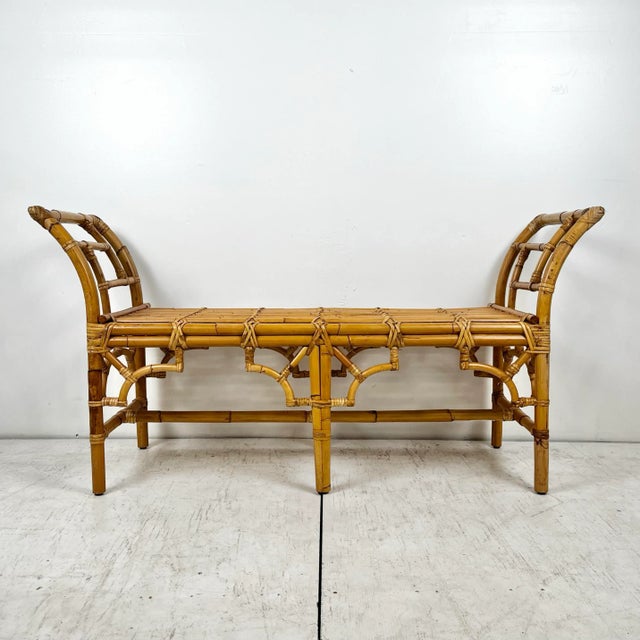 Vintage rattan bench. Long bench with Chinese chippendale fretwork detail. Cane wrapped joints. Curved arms on sides. A...