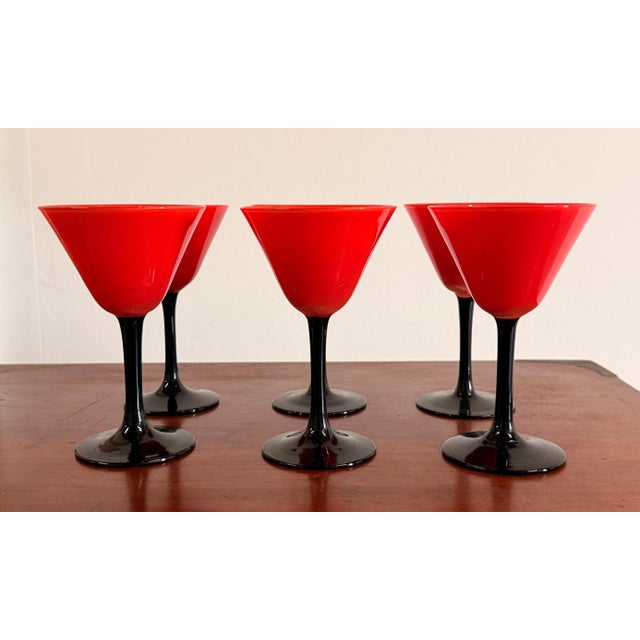 This set of six cordials is as good as this form gets, with vivid red opaline cups on elegant black glass stems and bases,...