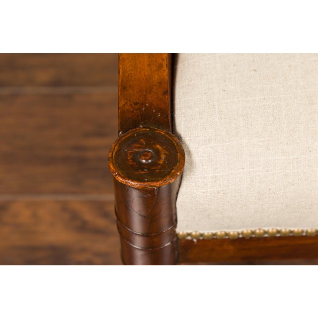 A French Restauration mahogany armchair from the 19th century, with carved rams' heads and new upholstery. Born in France...