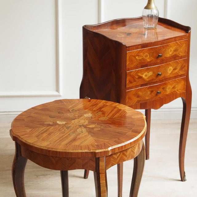 A small, three-drawer bedside table in the louis xv style, produced around 1900 as a reproduction of 18th-century models....