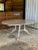 A substantial custom dining table by Modern History Home featuring a beautifully aged, distressed painted finish and...