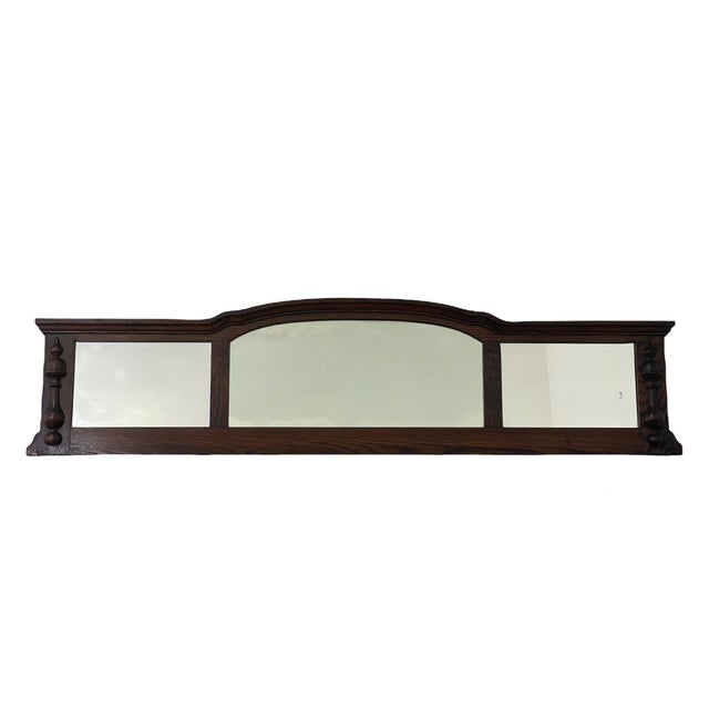 This vintage wall mirror features a long, horizontal three-panel design with a gently arched center mirror flanked by two...