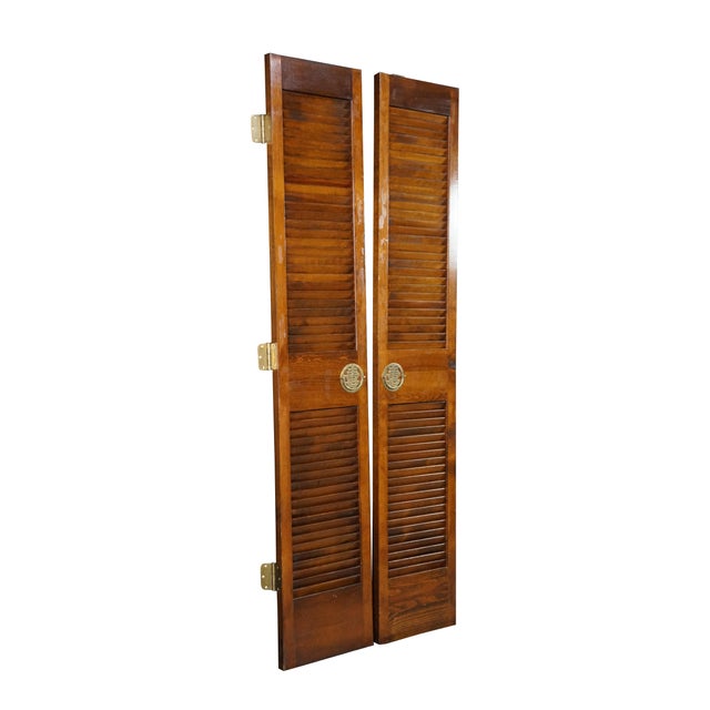 This pair of vintage mid-century Chinoiserie louvered doors is constructed from solid elm wood, showcasing a rich, warm...