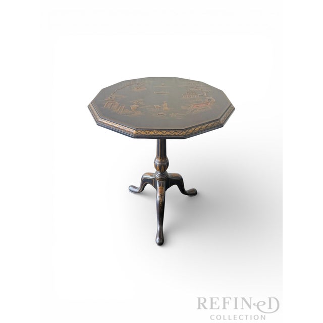 An exceptional Maitland-Smith Chinoiserie tilt-top table, masterfully hand-painted and richly detailed in gilt over a deep...
