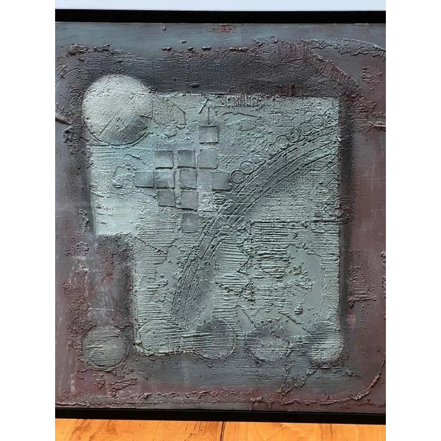 This square-framed abstract artwork, textured with blue-grey and purple hues, features an illegible signature and is dated...