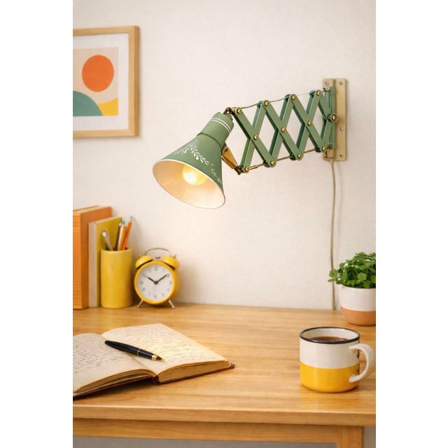 A vintage mid-century wall-mounted task lamp featuring a sage green painted tole shade with delicate foliate detailing and...