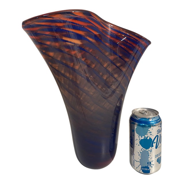 Offering a stunning studio made Art Glass vase. This murano style glass vase is a blue and orange swirl pattern with an...