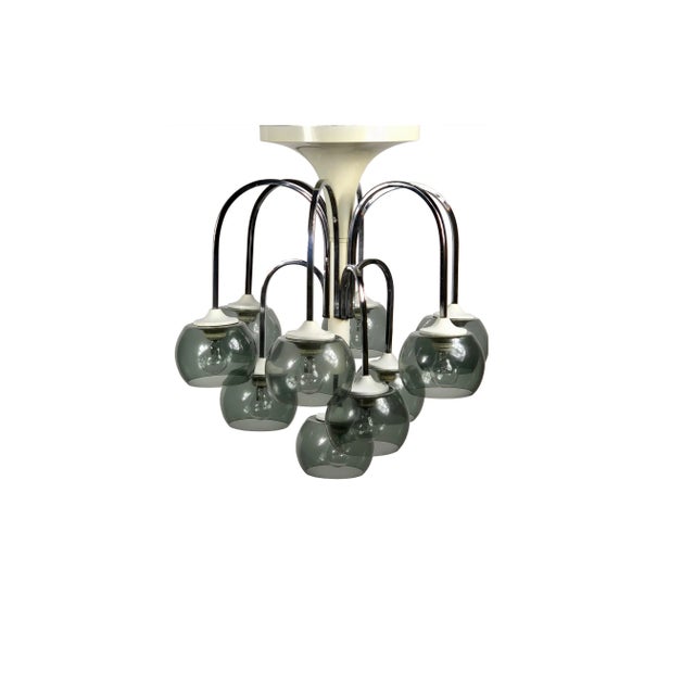Large chandelier featuring ten arched chrome arms supporting a smoked glass globe, inside which there is the light bulb....
