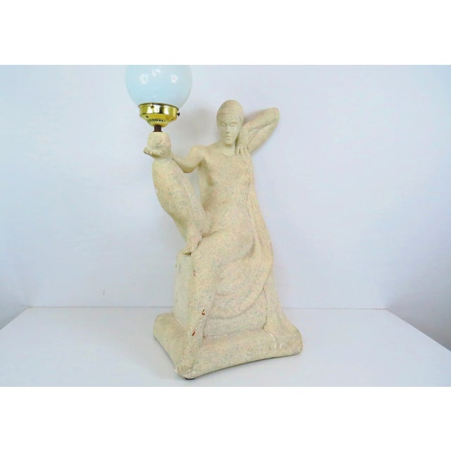 A large vintage 1970's French Art Deco inspired plaster table lamp. Lamp features sculptural reclining figure holding a...