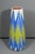 A tall, sculptural clay vase with a tapered silhouette and a bold modern geometric pattern in layered blue, purple, green,...