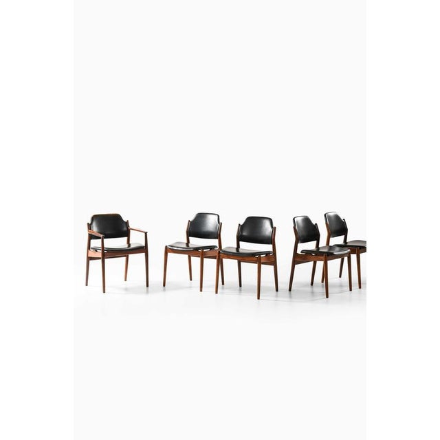 This rare and elegant set of six dining chairs—comprising four side chairs and two armchairs—was designed by arne vodder...