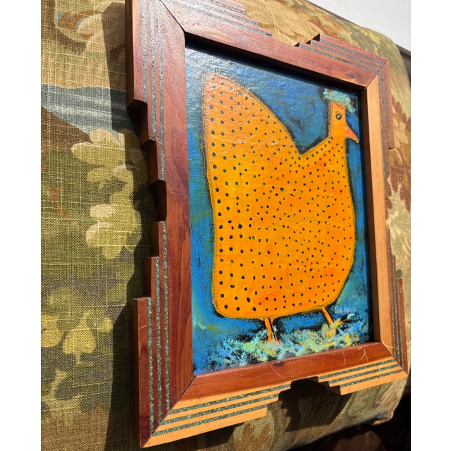 “Marigold” is a wonderful, funky chicken in orange with black speckles and impressive green and blue plumage on canvas...