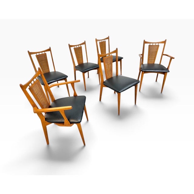 A stylish set of six Mid-Century Modern walnut dining chairs, circa 1960s, featuring warm wood tones, elegant proportions,...