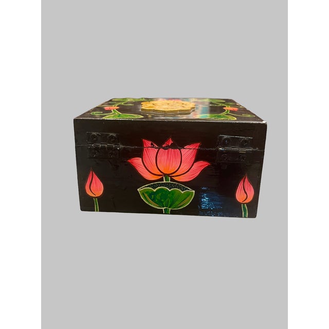 A beautifully handcrafted vintage wooden decorative box featuring vibrant hand-painted lotus flowers and an ornate gold...