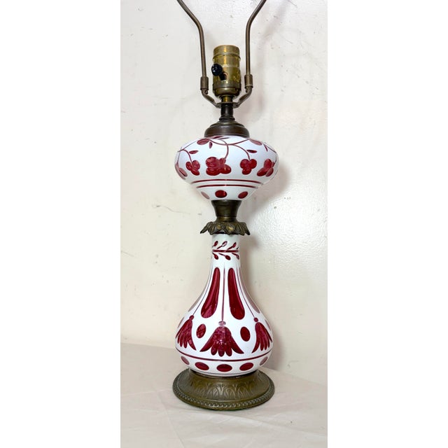 The Antique 19th century bronze mounted cut to clear cranberry glass electrified oil lamp is a unique and rare piece with...
