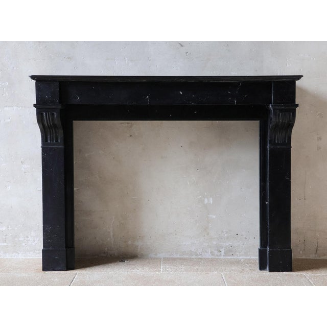 Sleek antique black marble mantel piece, Modillion model, from the early 20th century. Dutch, Amsterdam style fireplace,...