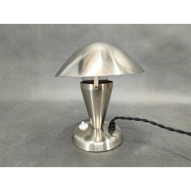 Elegant Bauhaus table lamp from 1930s Czechoslovakia, characterized by its clean lines and functional design. Crafted from...