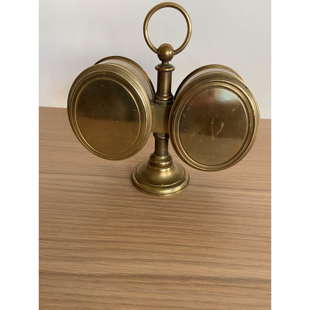 A handsome antique brass desk clock and aneroid barometer, c.1870, mounted on a pillar support with a round swing handle...
