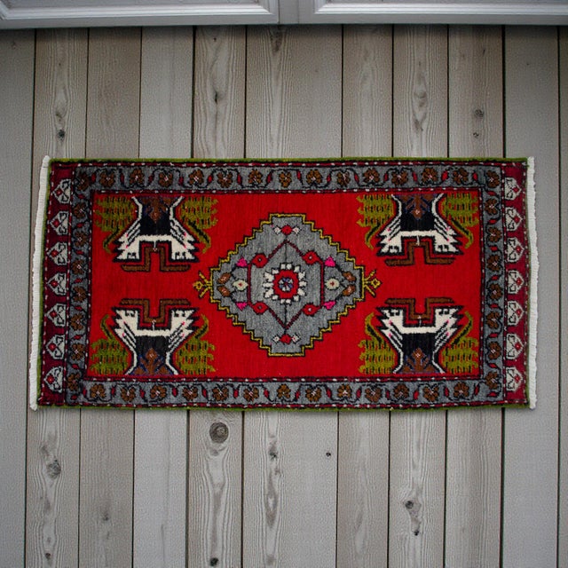 This vibrant hand-knotted Oushak mat brings a punch of saturated color and tribal energy to any small space. Its bold red...