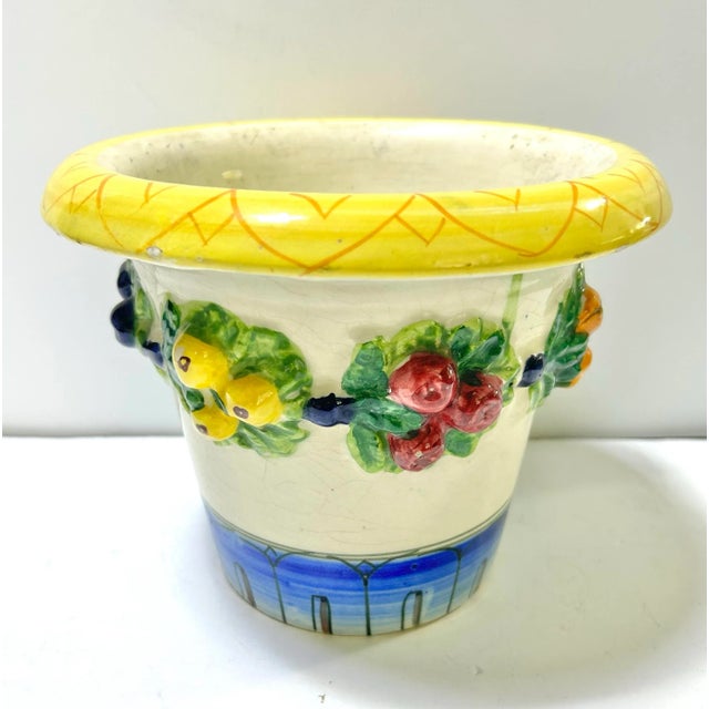 A vibrant Italian majolica cachepot featuring a sculpted fruit garland and richly glazed colors. This cheerful planter...