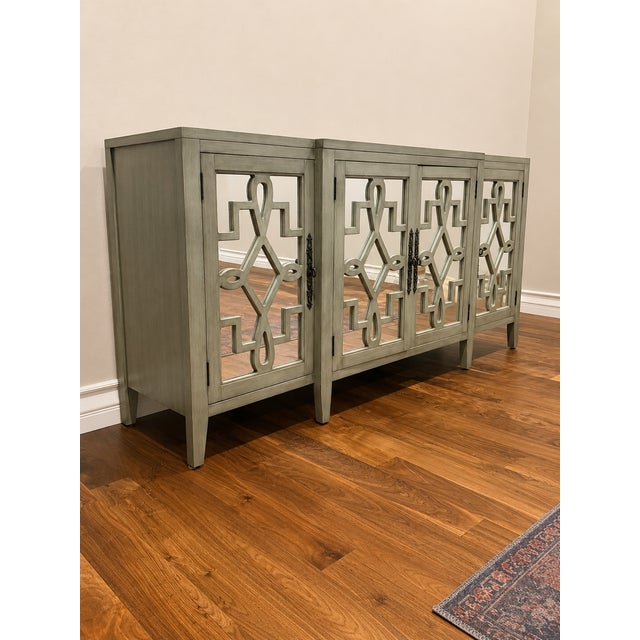 Architectural without feeling heavy, this contemporary four-door credenza features geometric mirrored doors in a soft...
