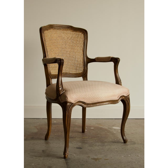 A finely carved French Louis XV style armchair by Kindel Furniture, with a serpentine caned back framed in molded walnut,...