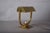 Compact brass desk lamp attributed to the 1930s. A broad U-shaped frame rises from a stepped rectangular base to support a...