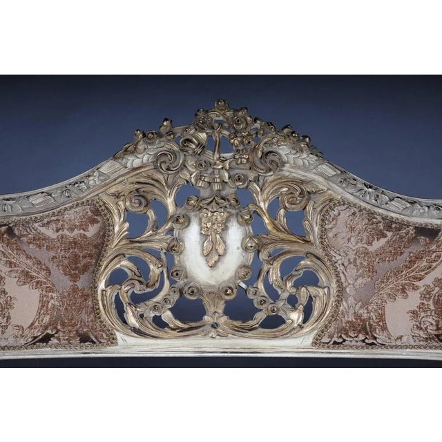 Solid beechwood, carved and gilt gilded. Semicircular rising, curved backrest framing with center bar and rocaille...
