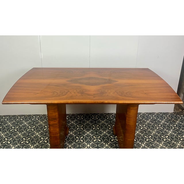 Vintage Art Deco dining table, dating from the 1930s. The table is primarily crafted from burr walnut, often featuring...