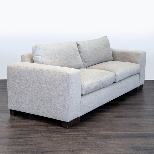 This Kreiss loveseat features a clean, modern design with wide arms and thick, plush cushions. The soft neutral fabric...