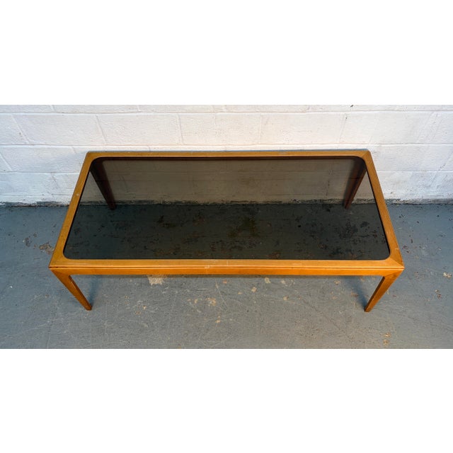 An elegant, elongated Mid-Century Modern coffee table featuring a rich American Walnut frame and a signature frosted glass...