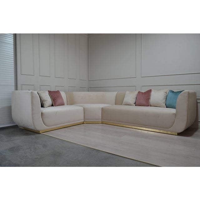 A sophisticated L-shaped sectional sofa featuring a sculptural silhouette, softly rounded edges, and generous upholstered...